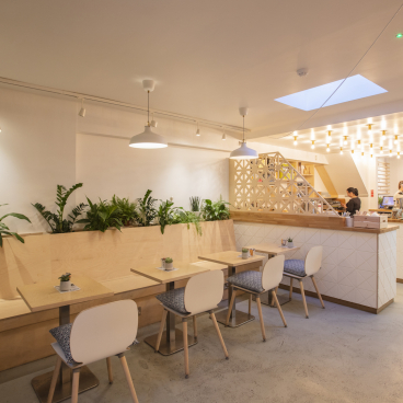 Modern café interior featuring wooden tables, potted plants, and an inviting service counter designed by Liqui Group in Dublin.