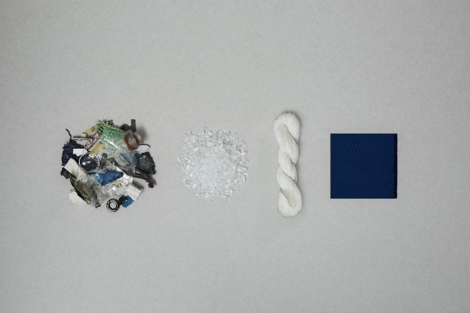 Materials for sustainable fabric: marine plastic waste, processed plastic, rope, and a finished textile sample from Camira.