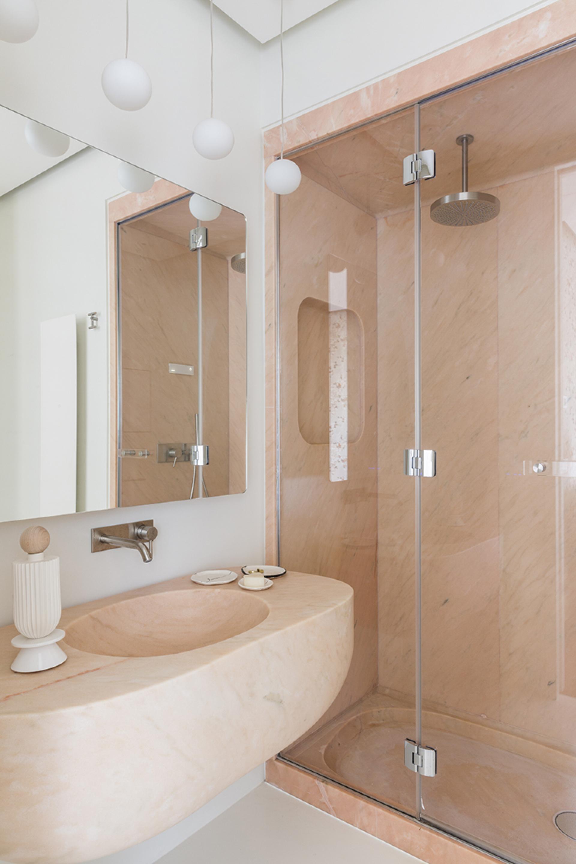 Stylish bathroom featuring a marble sink, modern shower enclosure, and elegant lighting above.