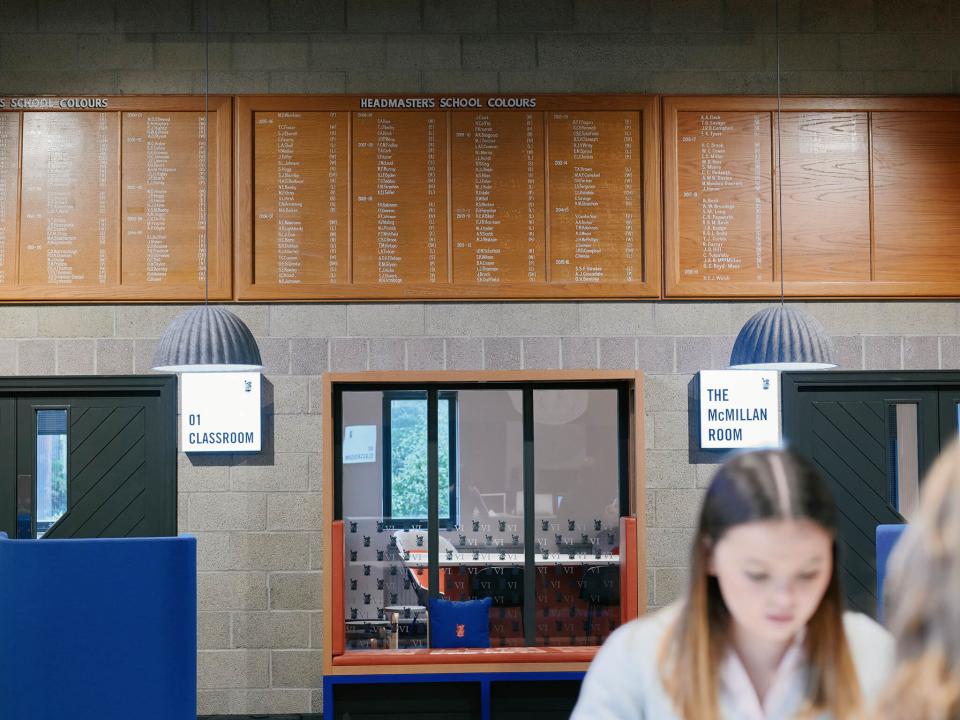 Renovated interior of Sedbergh School's Queens Hall featuring classroom signs, wooden boards, and contemporary lighting design.