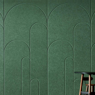 Modern green wall design with curved patterns, accompanied by a minimalist table and vase, showcasing innovative workspace aesthetics.