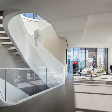 Luxurious interior of Zaha Hadid's West Chelsea penthouse featuring a sweeping staircase and elegant living area.