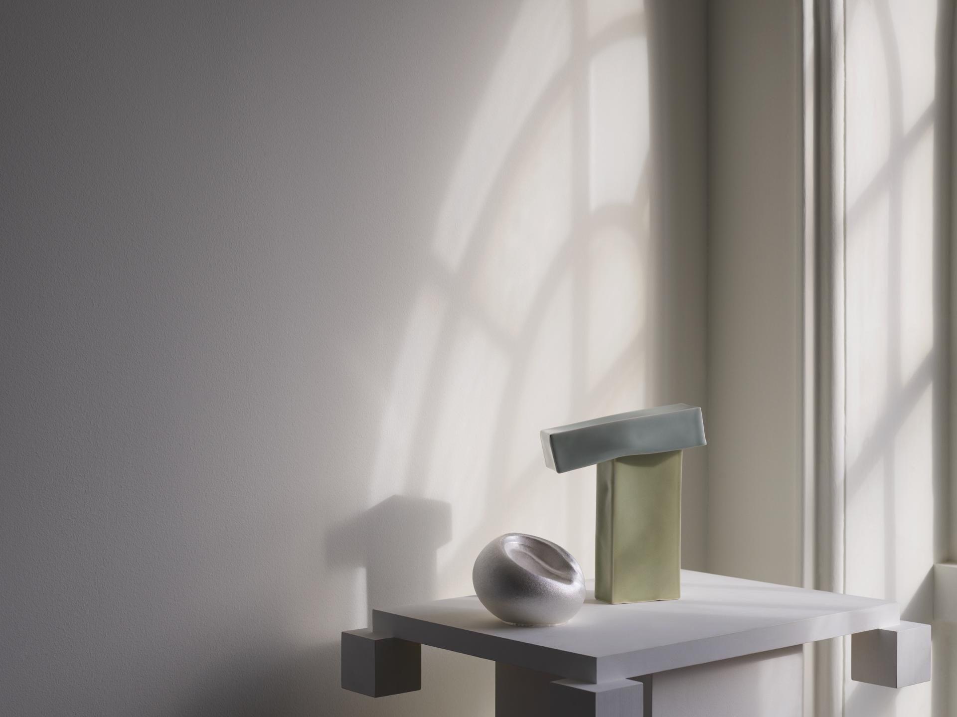 Contemporary ceramic sculptures showcased on a pedestal, illuminated by soft natural light at Collect 2023 in Somerset House.