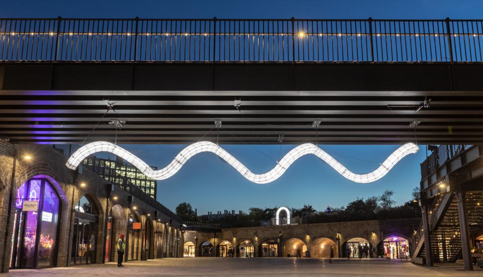 Giant sculptural light installation by Studio Mieke Meijer at Coal Drops Yard, illuminated under the evening sky.