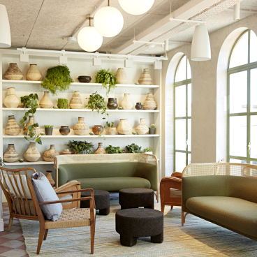 Stylish lounge featuring Scandinavian furniture and African crafts, with greenery and woven decor in a cozy setting.