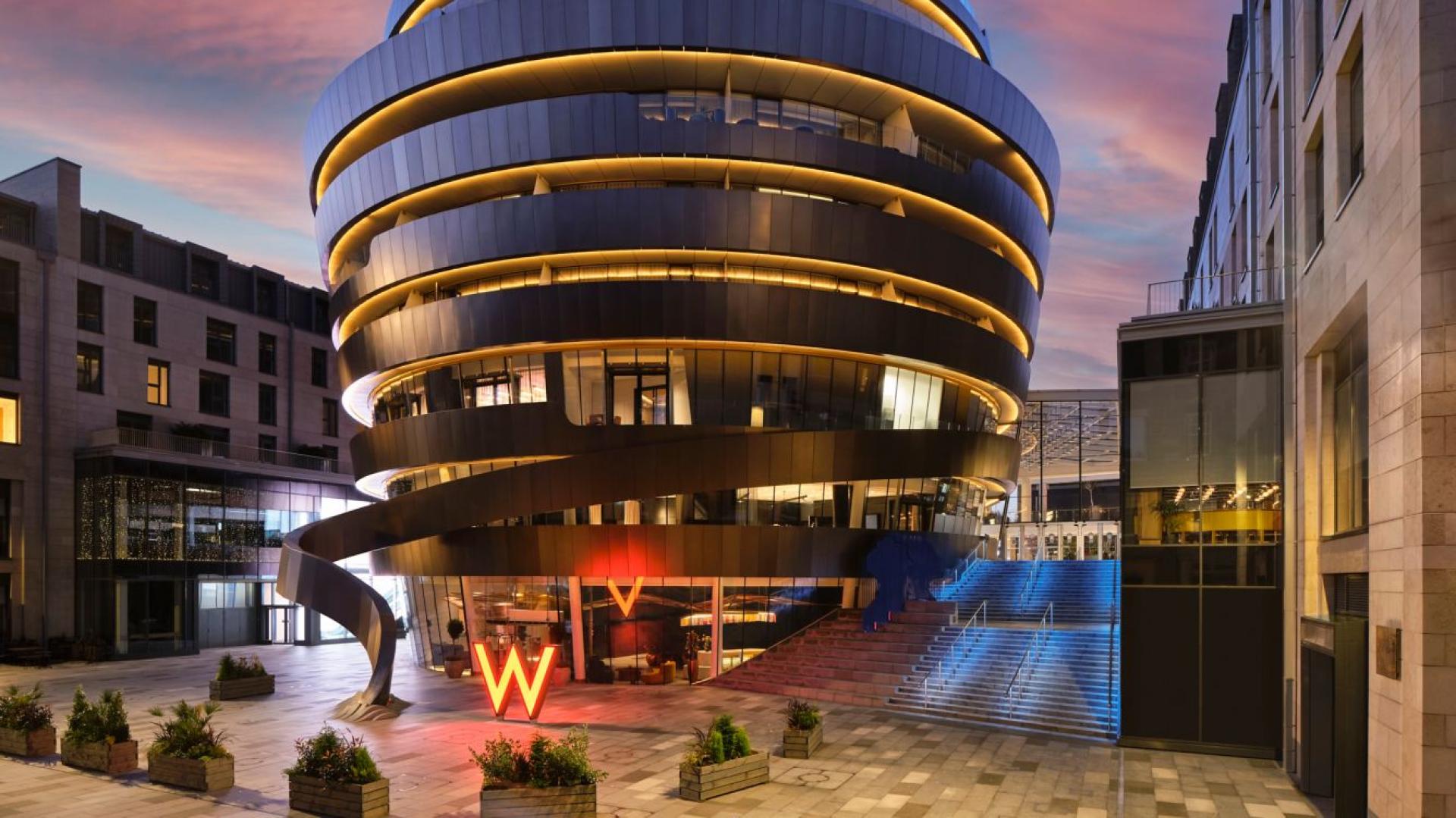 W Hotel Edinburgh features a stunning modern architecture with illuminated design elements at dusk, located in St James Quarter.