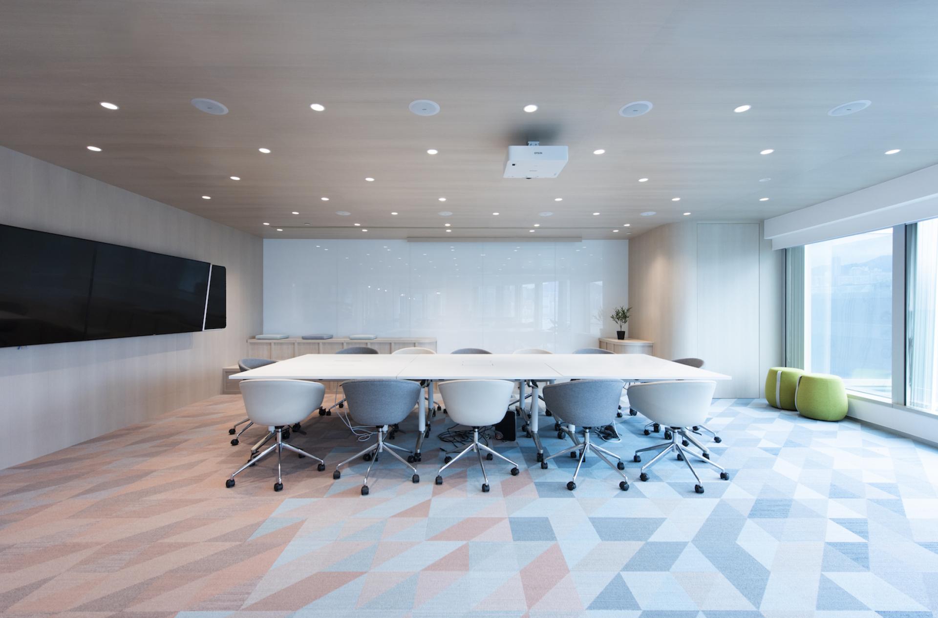 Modern conference room design featuring a large table, ergonomic chairs, and a minimalist aesthetic for Jardine Restaurant Group.