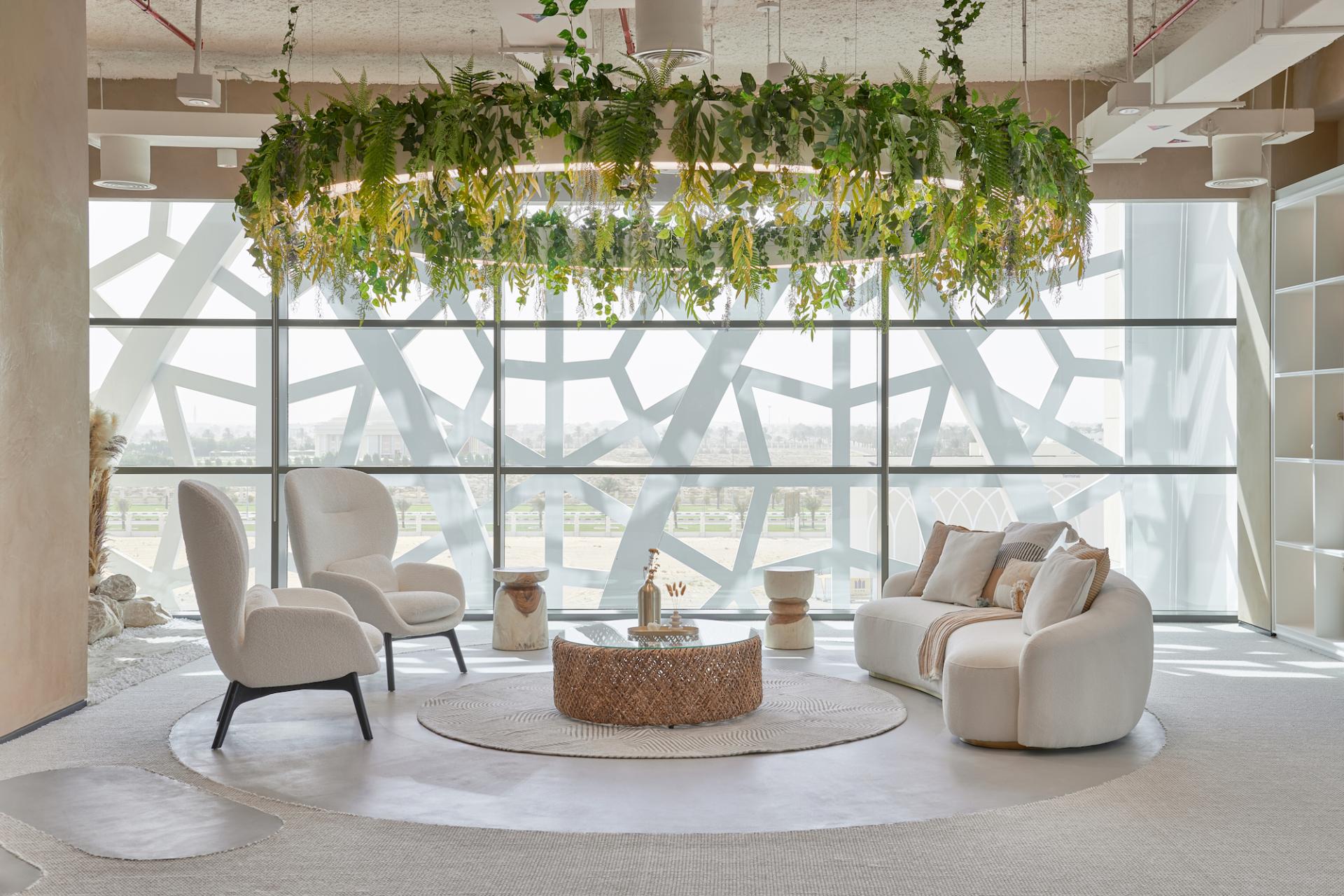 A modern, inviting lounge area with plants, comfortable seating, and large windows in the entrepreneurship center.