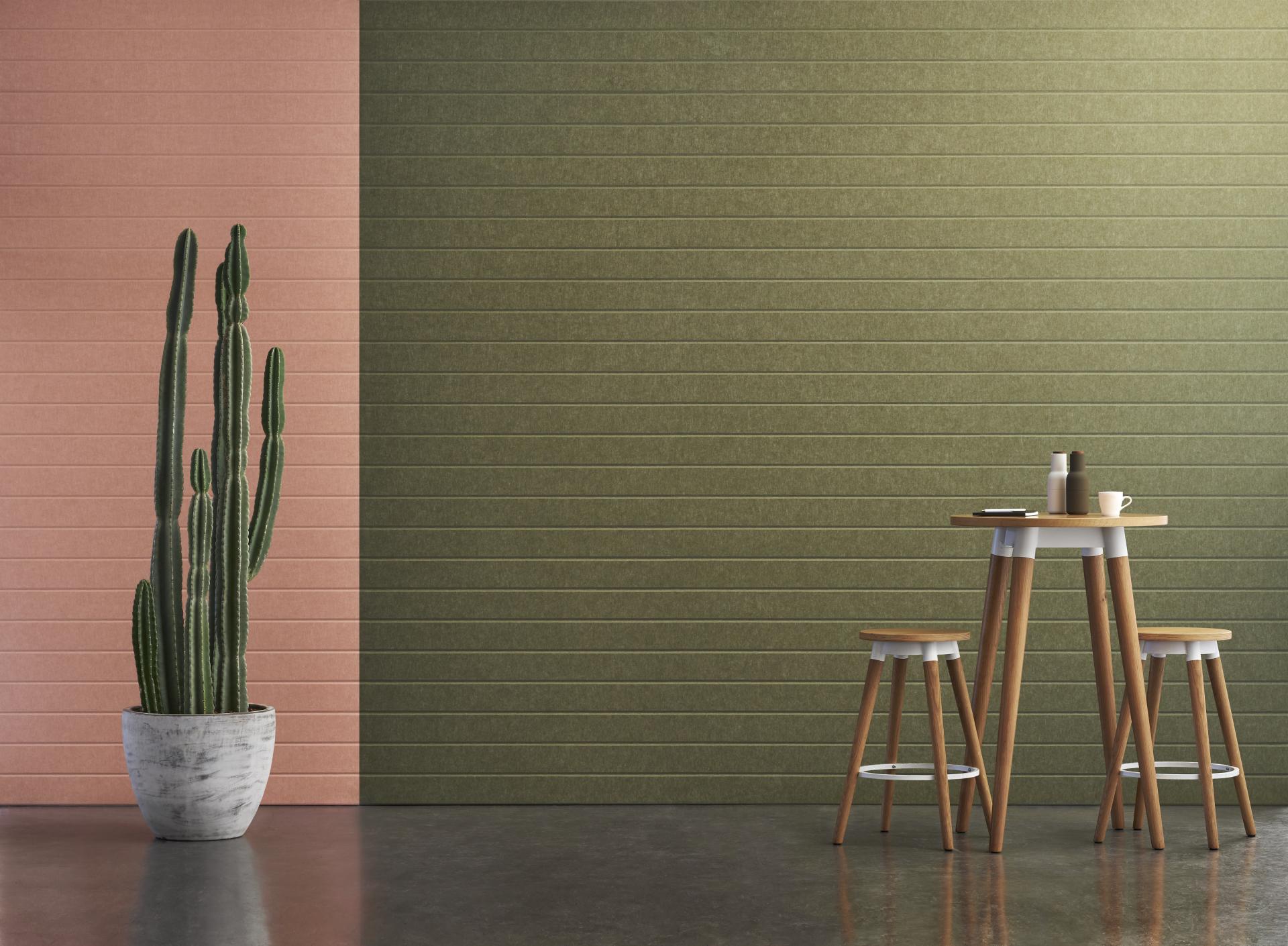 Stylish interior featuring Woven Image's EchoPanel® in pink and green, with modern furniture and a potted cactus.