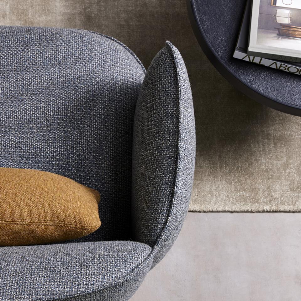 Stylish armchair featuring Camira's Main Line Twist tweed upholstery, accented with a mustard pillow and sleek coffee table.