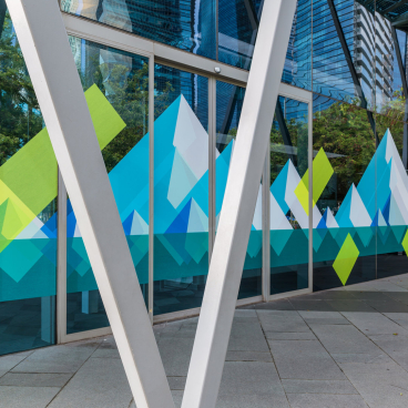 Colorful geometric designs on glass exterior reflecting modern architecture, showcasing HARU Stuck-on Design's innovative approach to interior aesthetics.