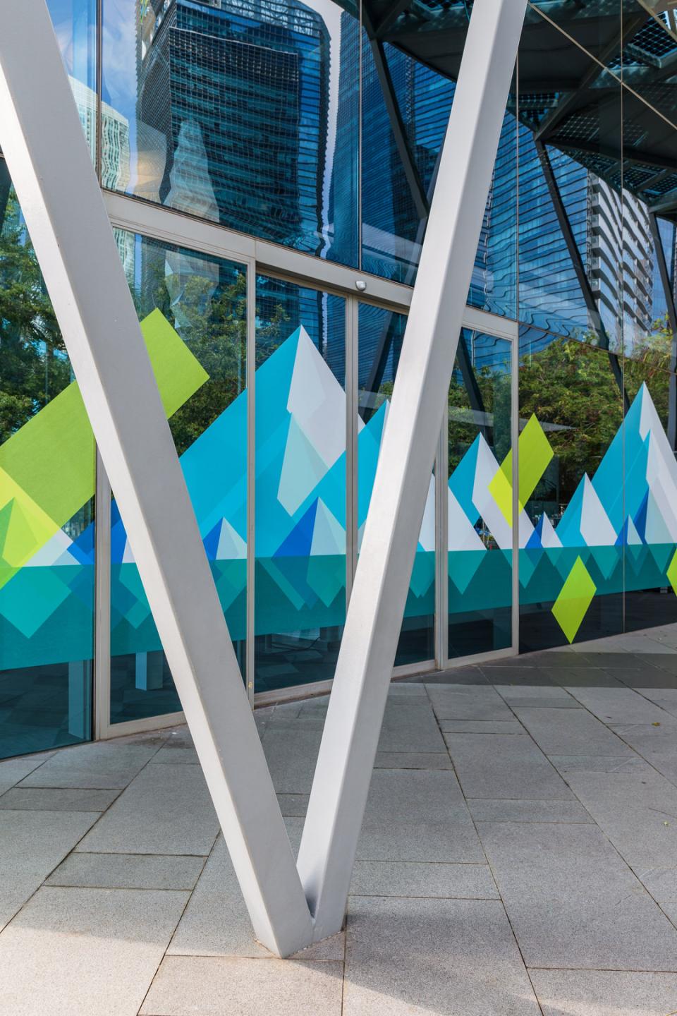 Colorful geometric designs on glass exterior reflecting modern architecture, showcasing HARU Stuck-on Design's innovative approach to interior aesthetics.