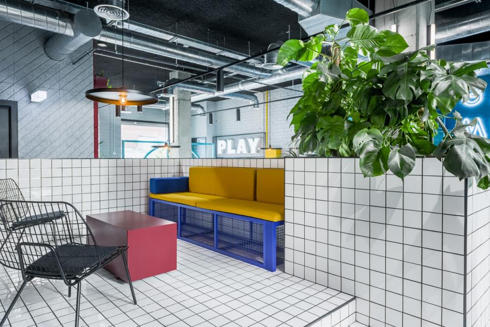 Modern co-living space at The Student Hotel Barcelona featuring vibrant seating, greenery, and playful design elements.