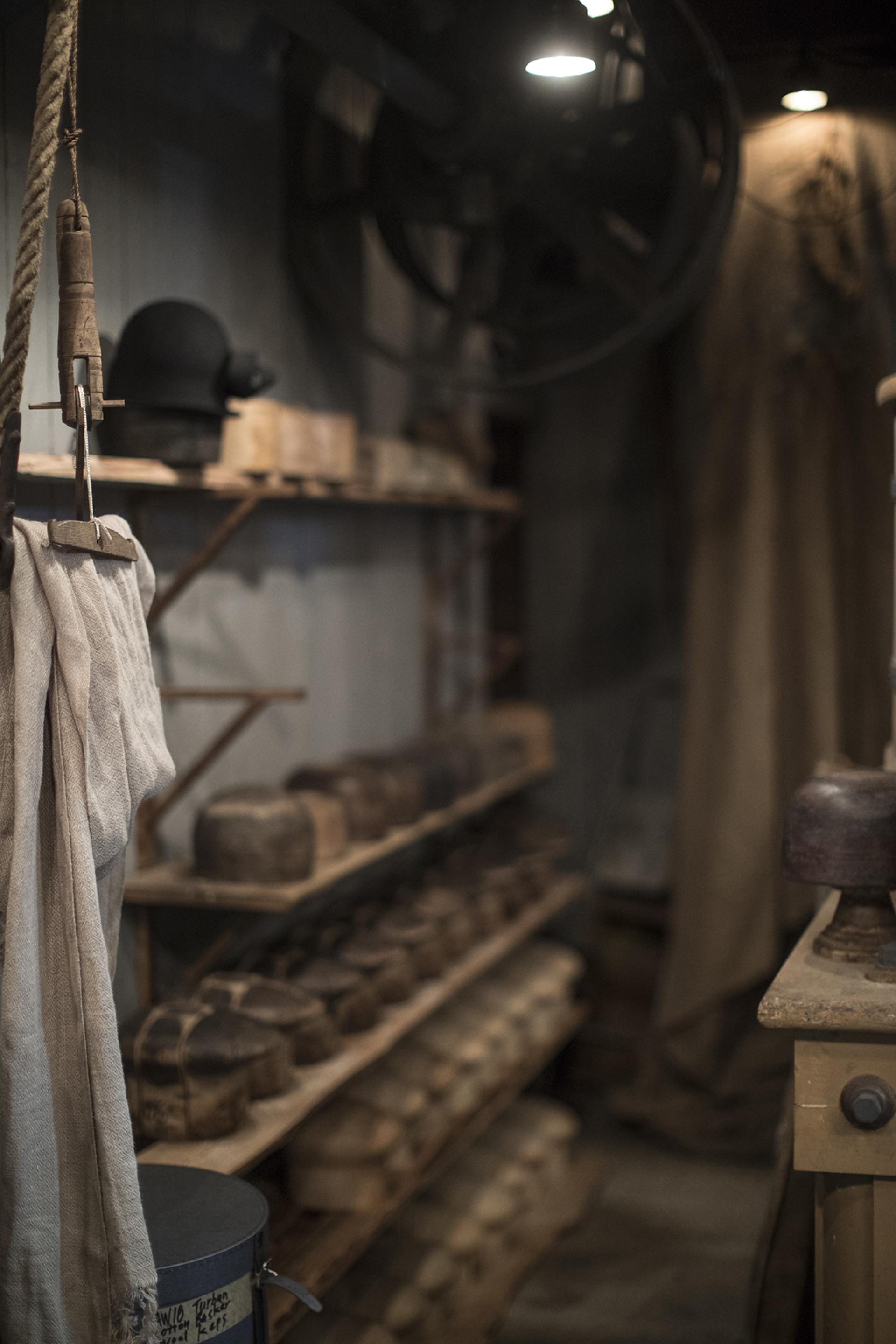 Interior of Horisaki workshop, showcasing wooden hat molds and traditional hat-making tools in Småland's forest setting.