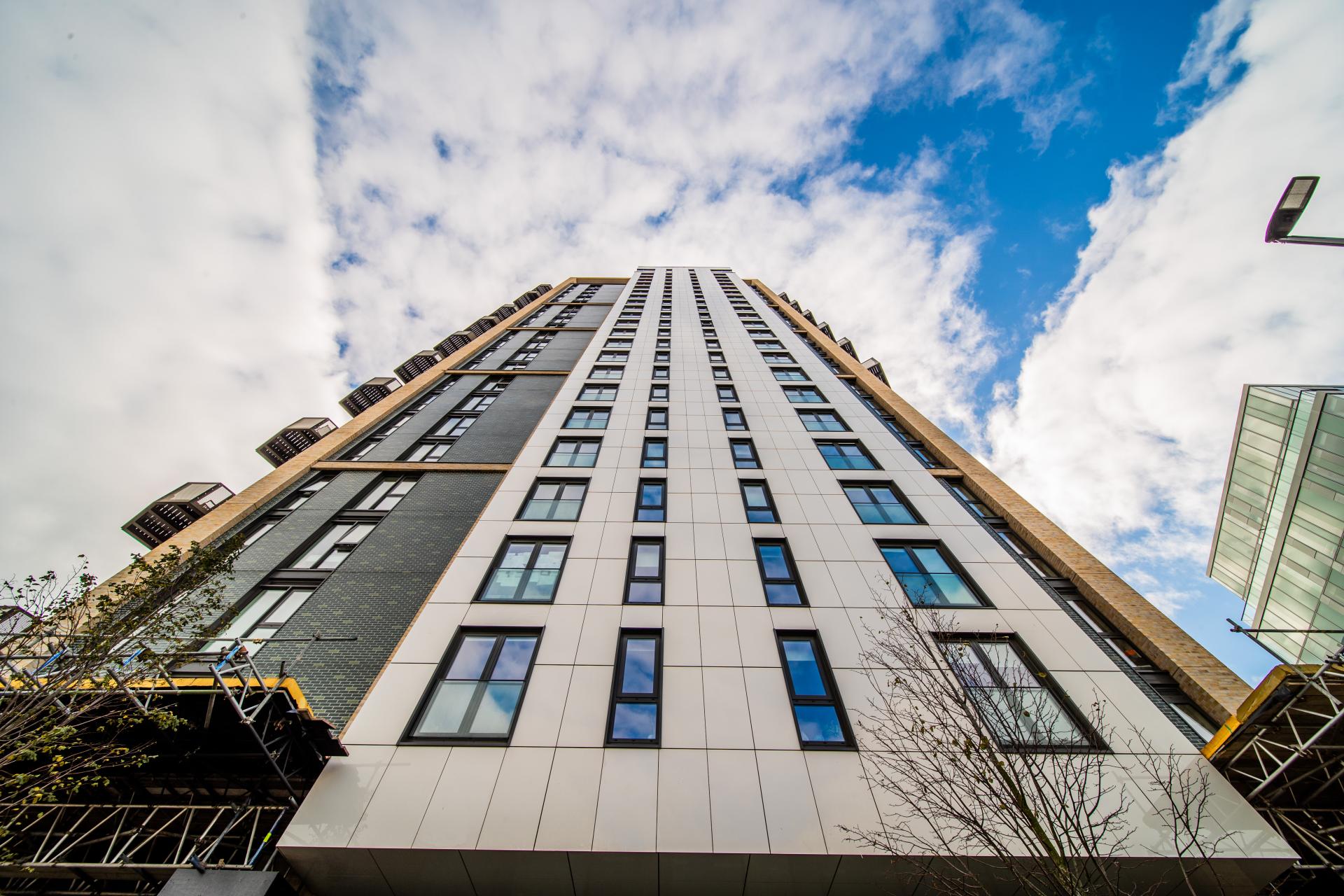 London high-rise building featuring Dekton façade with modern architecture and cloudy blue sky backdrop.
