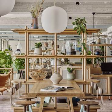 Stylish interior of WunderLocke in Munich featuring natural decor, modern furniture, and vibrant greenery.