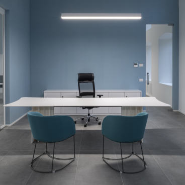 Modern office space at T&T headquarters features a sleek design with a minimalist desk and vibrant blue accents.