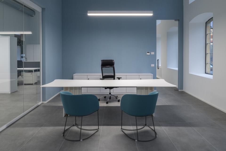Modern office space at T&T headquarters features a sleek design with a minimalist desk and vibrant blue accents.