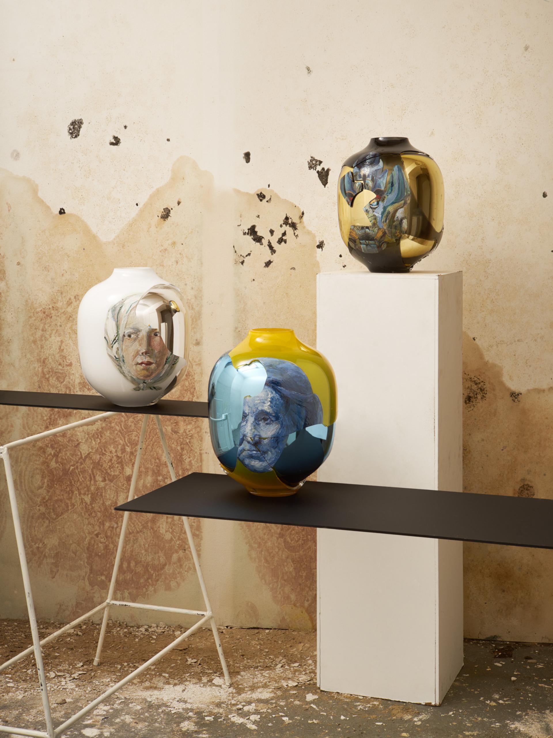 Artistic glass vases featuring intricate designs and reflections, displayed at the London Design Fair showcasing innovative glasswork.