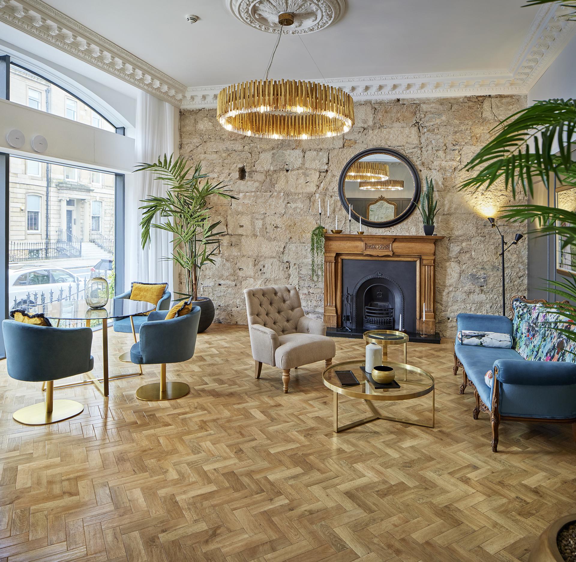 Stylish living area featuring Karndean Designflooring, custom furniture, and historic stone walls in Glasgow's CoVault building.