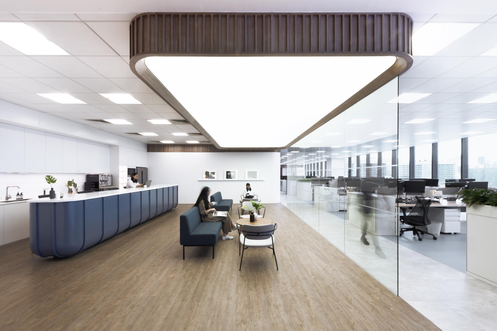 Modern office interior designed by Bean Buro featuring an open layout, seating area, and internal staircase.