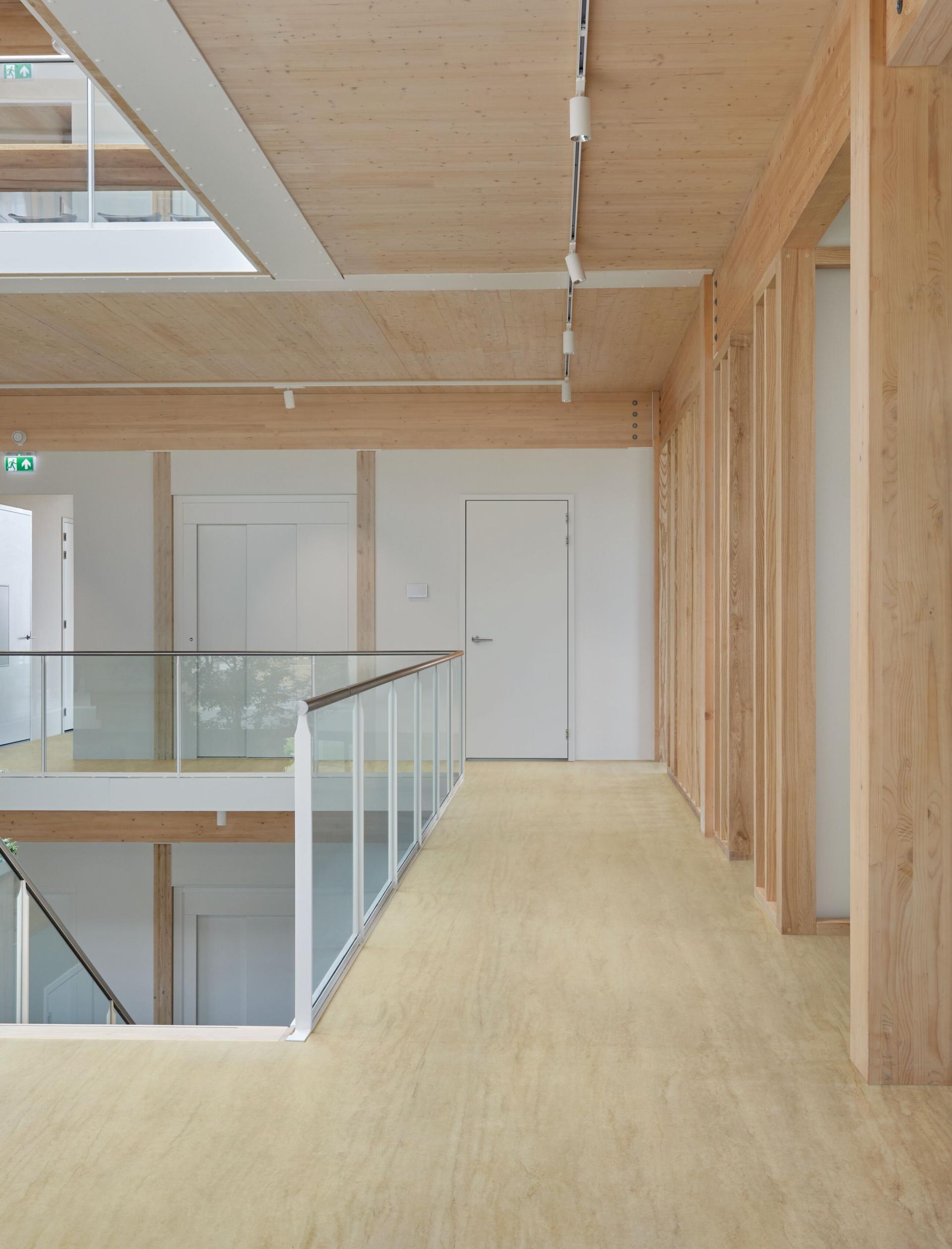 Wood panelling lines the walls with a glass staircase in the middle of the shot