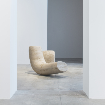 Organic sculptural chair by Wendell Castle displayed in a minimalist gallery space, highlighting the designer's innovative style.