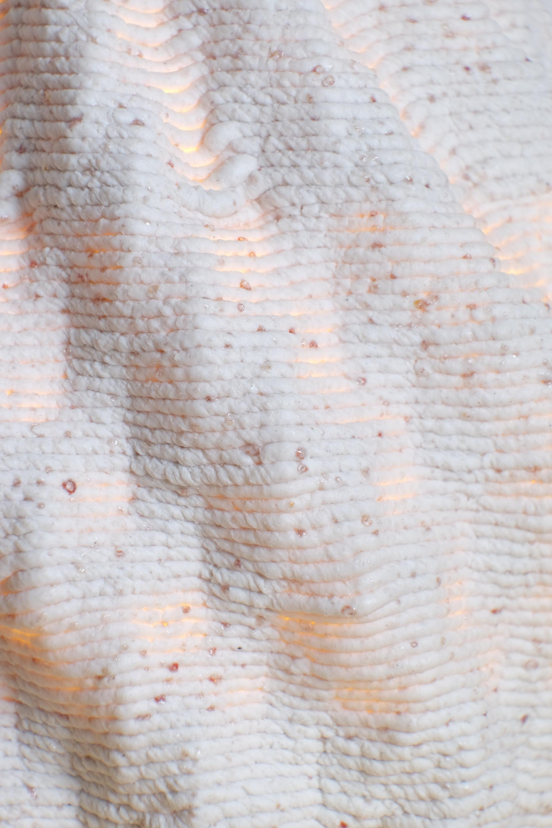 Textured surface of a 3D printed lamp made from recycled ceramics, showcasing sustainable design and ambient lighting.