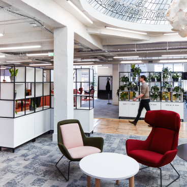 Modern office space at Queen Mary University, featuring collaborative areas and greenery, promoting innovative work environments.