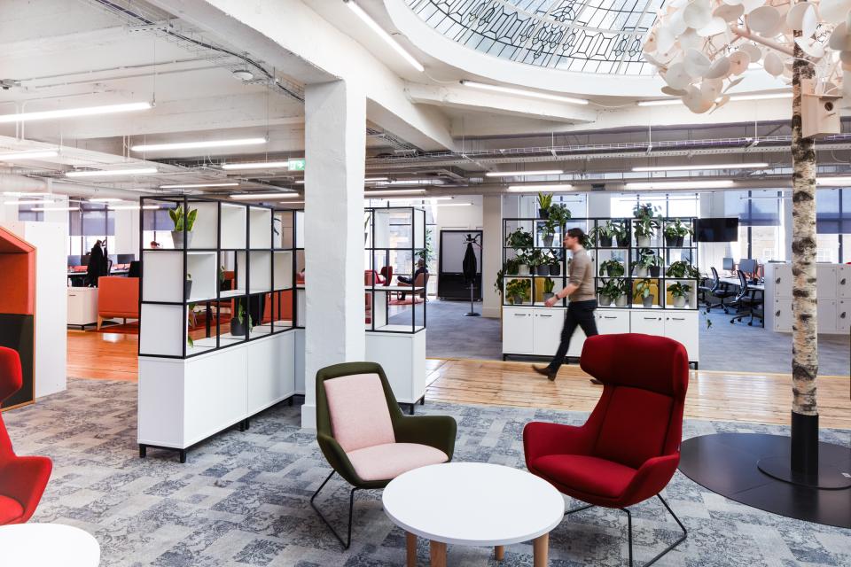 Modern office space at Queen Mary University, featuring collaborative areas and greenery, promoting innovative work environments.