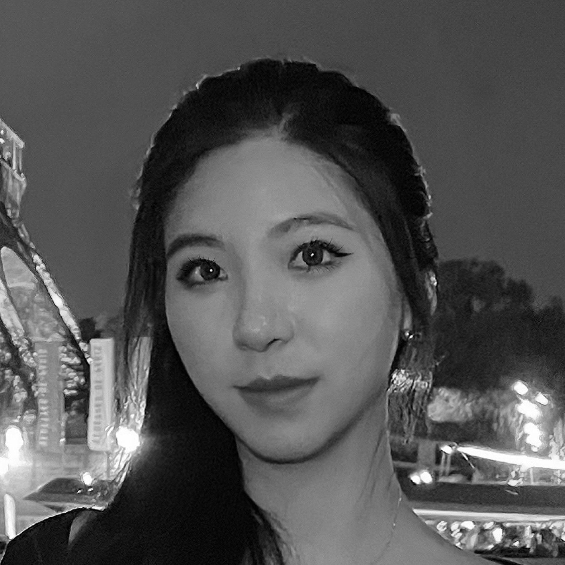 A woman stands near the Eiffel Tower, showcasing urban architecture's aesthetic appeal amidst nighttime surroundings.