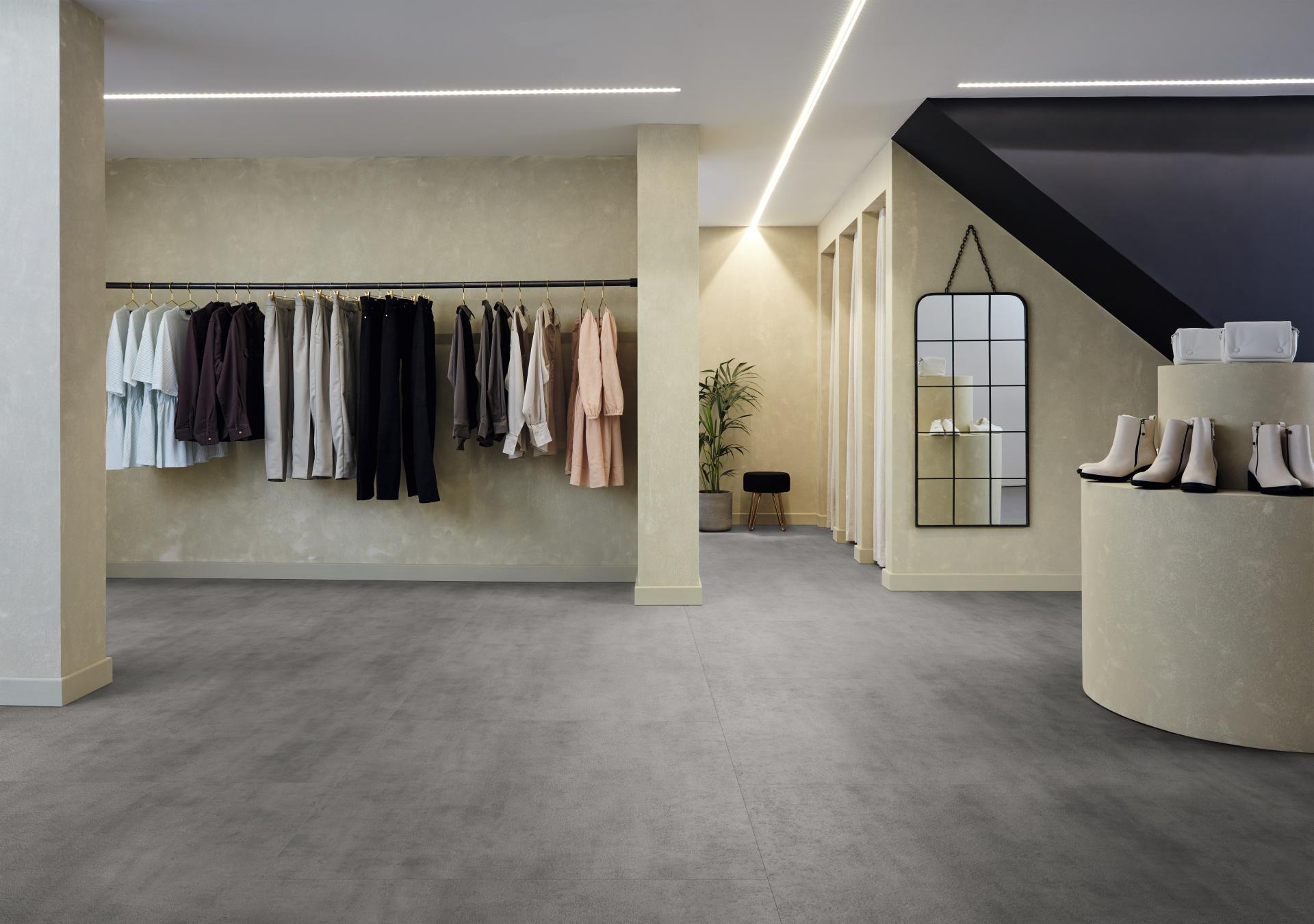 Extra-large concrete-look tiles from Karndean Designflooring featured in a modern retail space with clothing displays.
