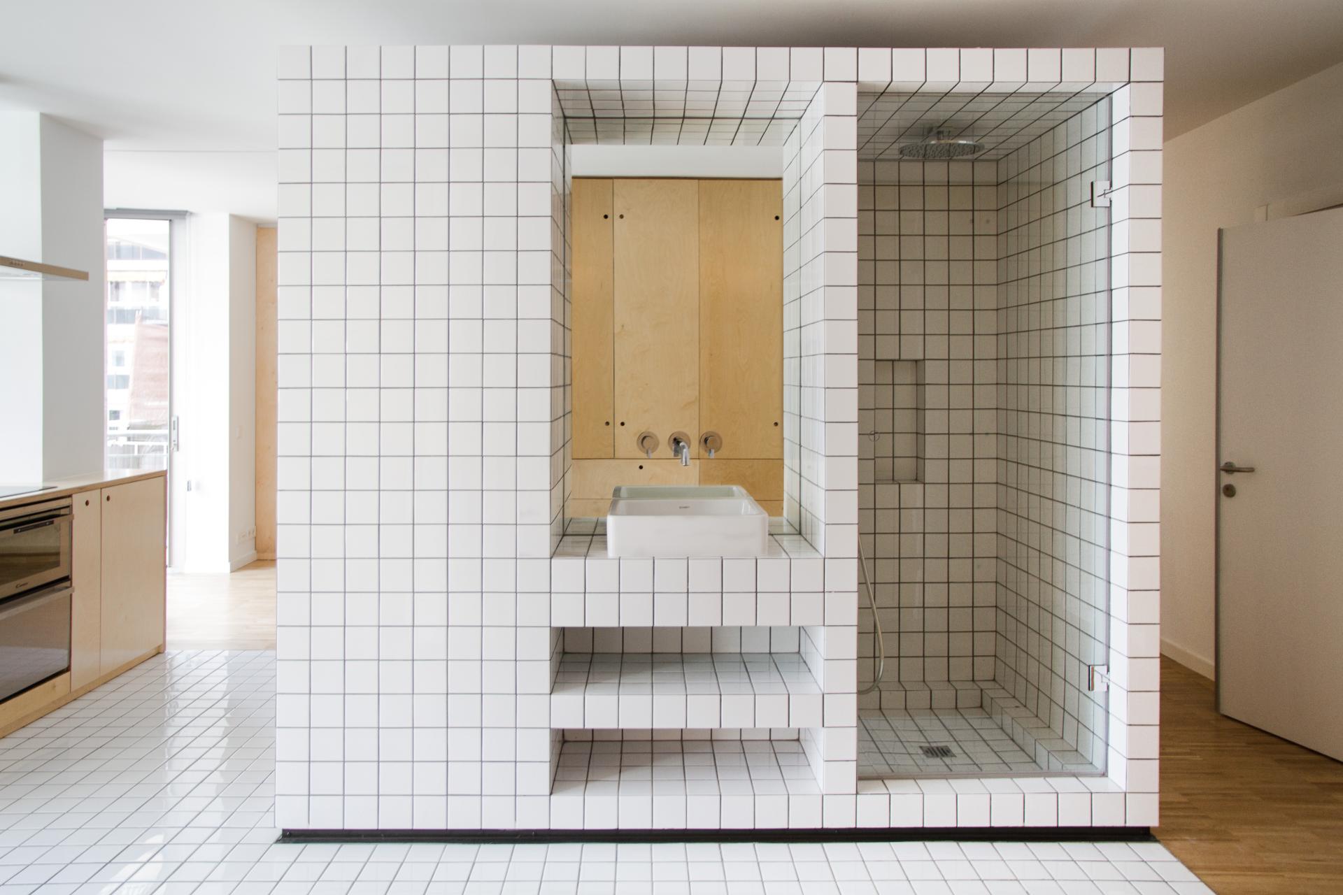 Modern bathroom featuring innovative ceramic tiles, a minimalist sink, and a stylish shower enclosure.