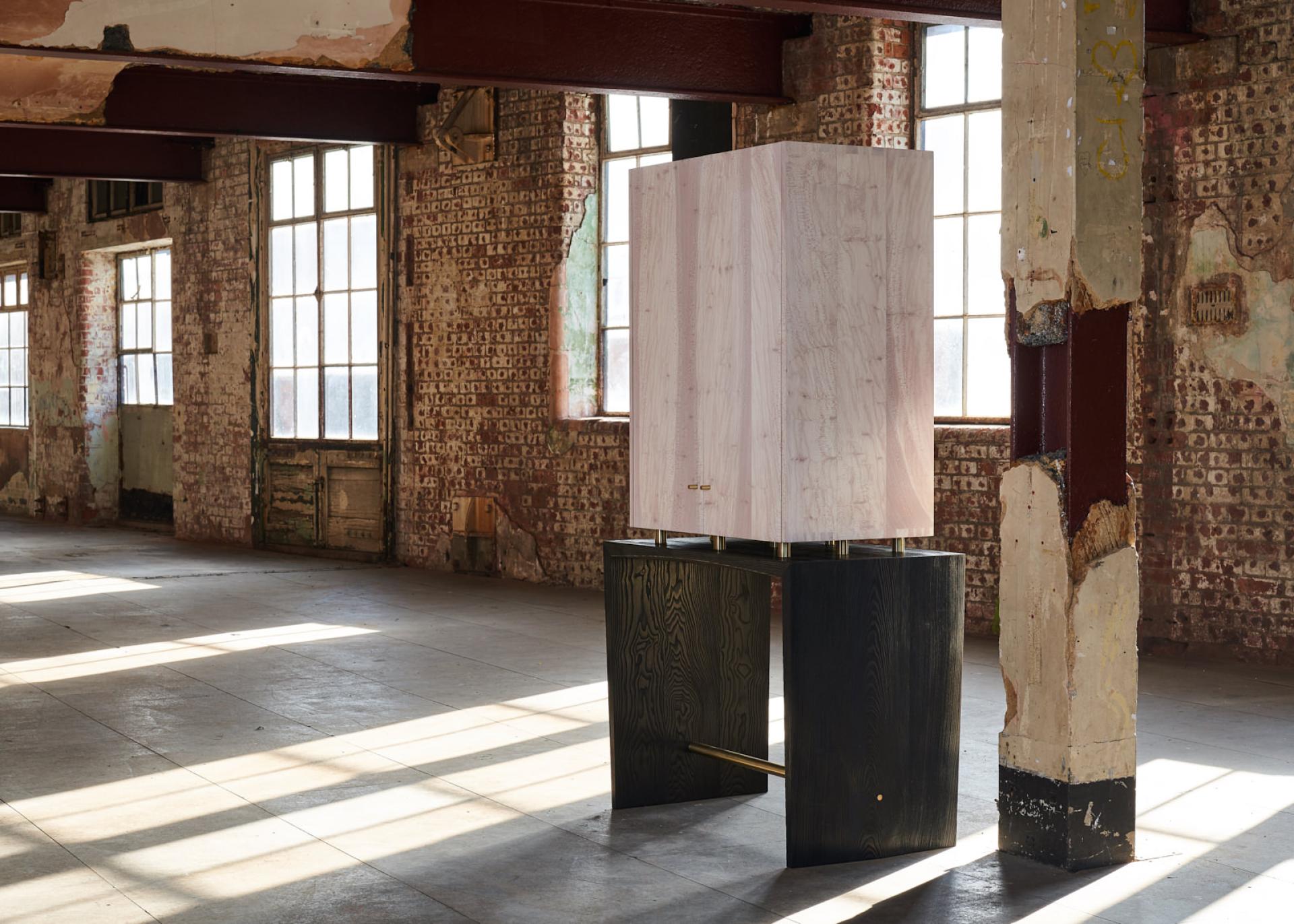 Innovative contemporary cabinet design showcased in a vibrant industrial space at London's Bargehouse exhibition.