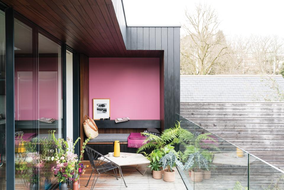 Stylish outdoor seating area featuring Farrow & Ball's Sulking Room Pink against a modern backdrop with greenery.