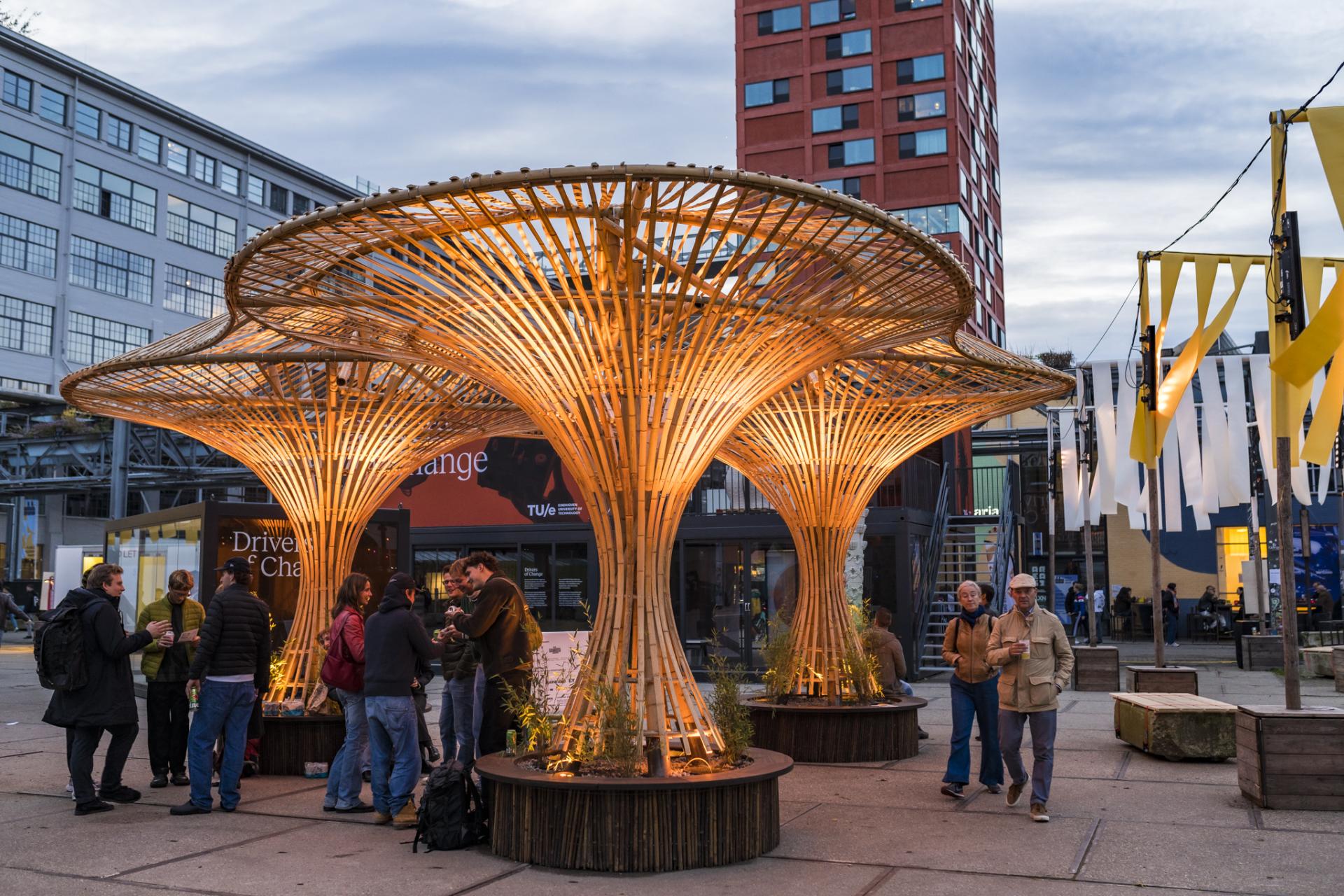 Innovative bamboo structure serving as a gathering space, showcasing biomaterials and sustainable design principles in an urban setting.