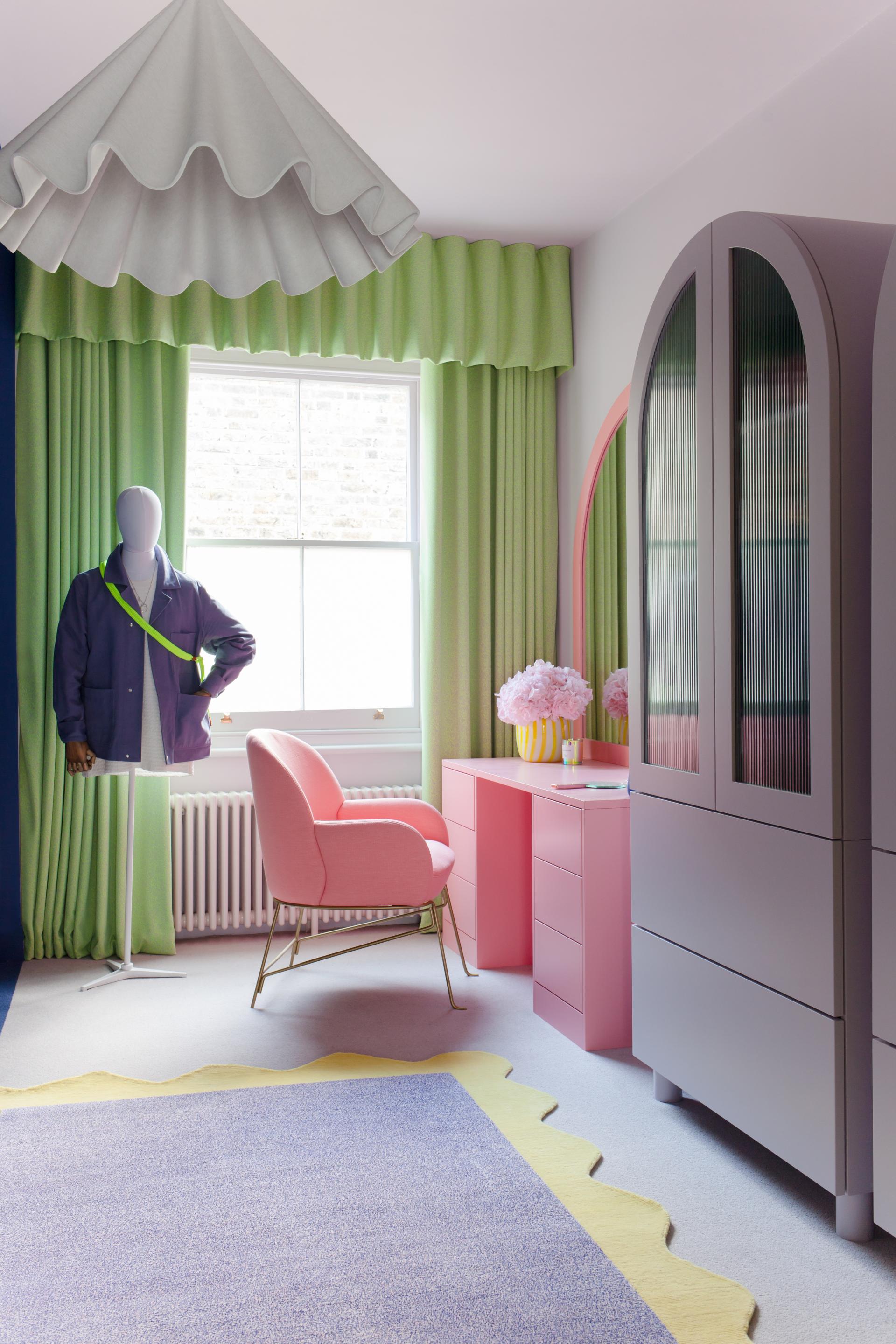Vibrant interior featuring a pink chair, green curtains, and a stylish rug, showcasing 2LG Studio’s design aesthetics.