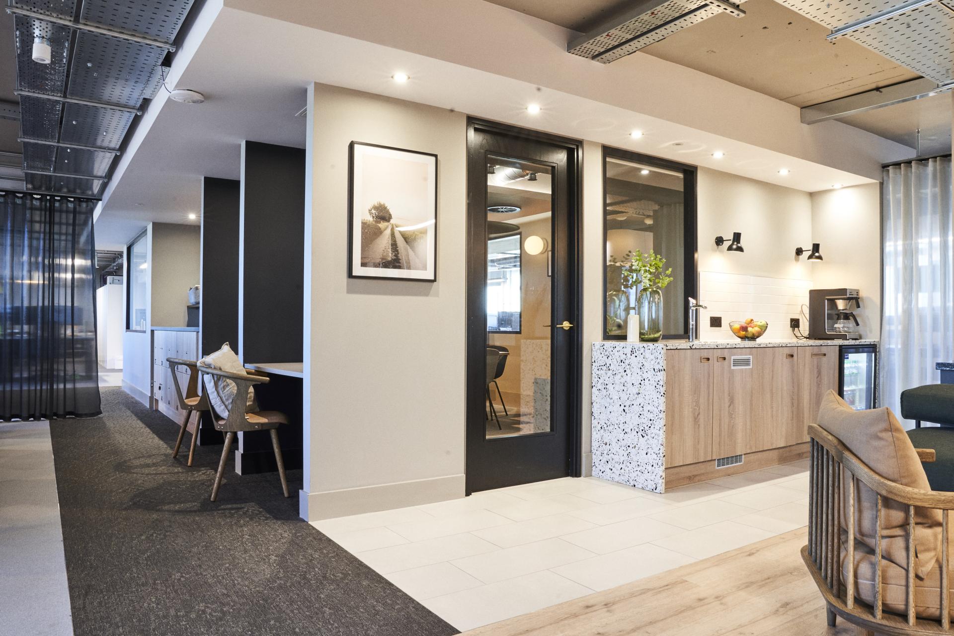 Modern interior design featuring an open layout with stylish furniture, a kitchen area, and natural decor elements.