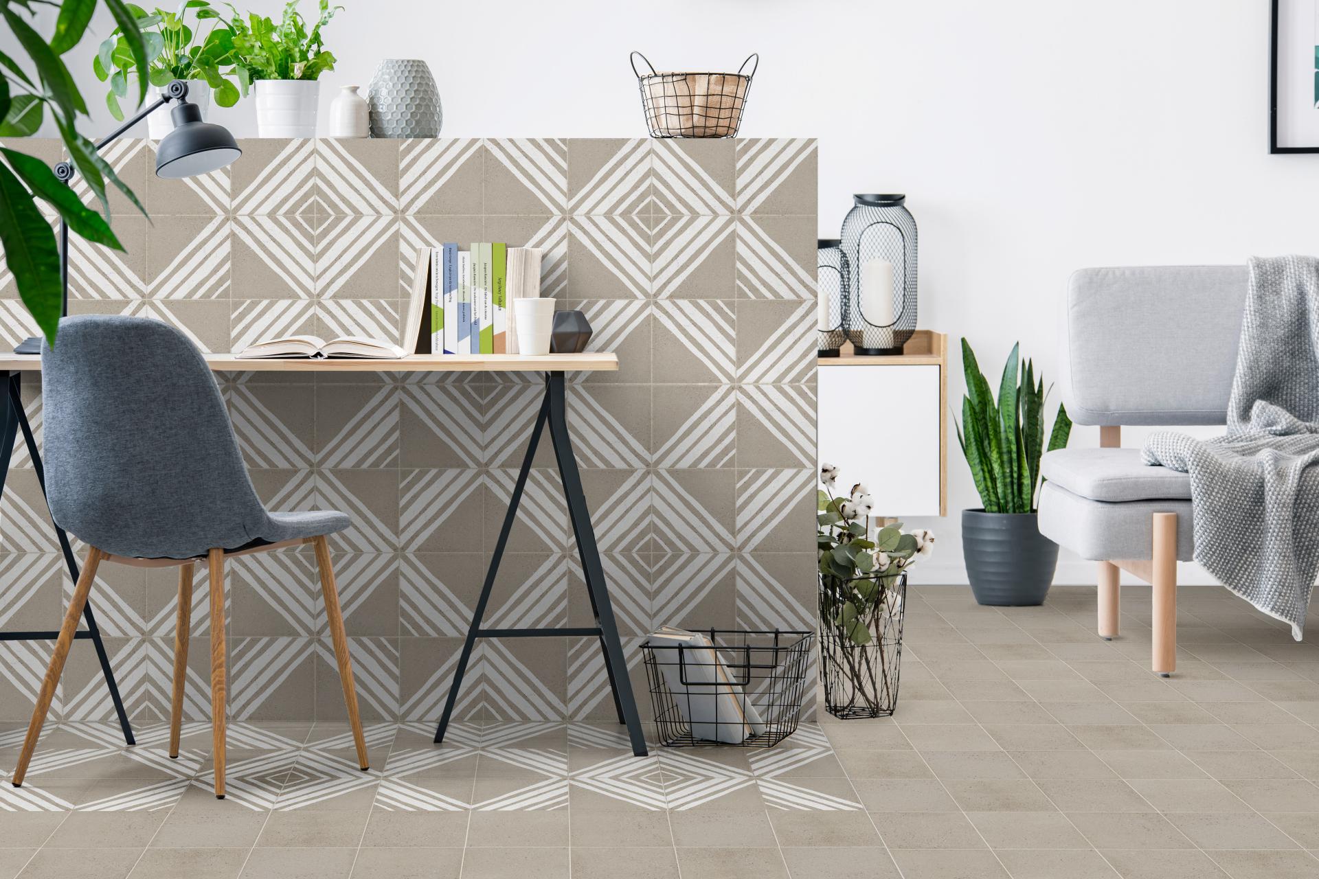 Modern workspace with geometric patterned tiles, stylish furniture, and greenery, showcasing 2019 tile design trends at Cevisama.