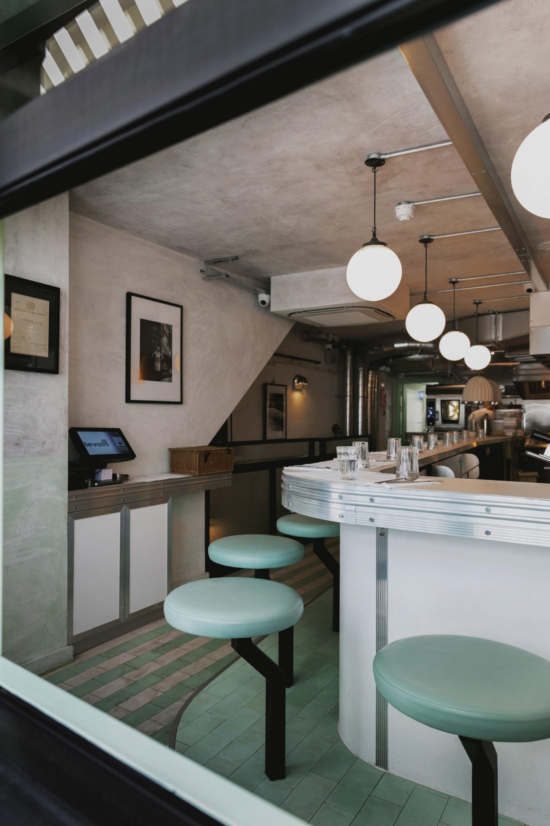 Art Deco-inspired interior of Lina Stores in Soho, featuring green and white striped decor and stylish stools.