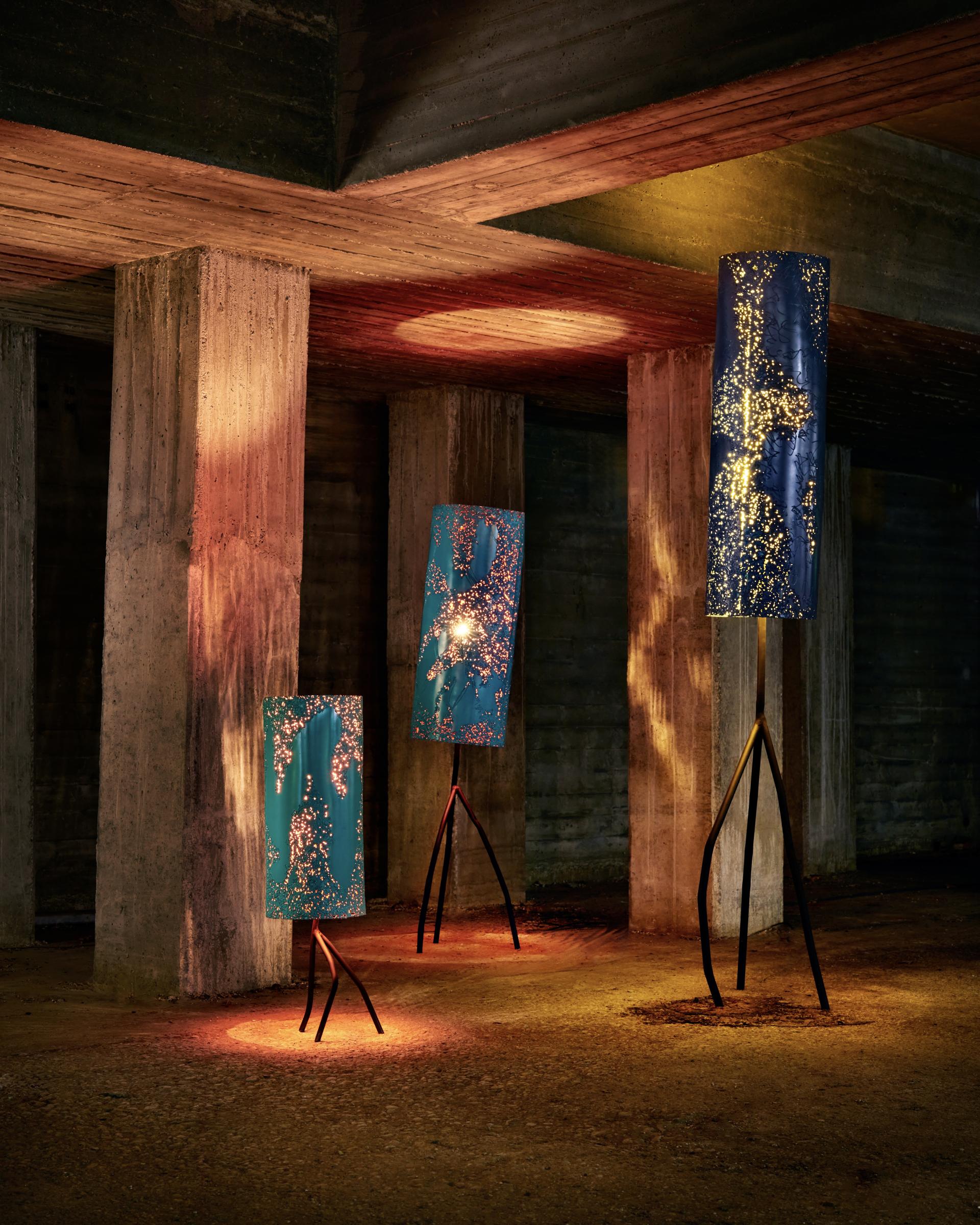 Contemporary floor lamps with intricate designs, illuminated under a modern architectural setting at Salone del Mobile exhibition.