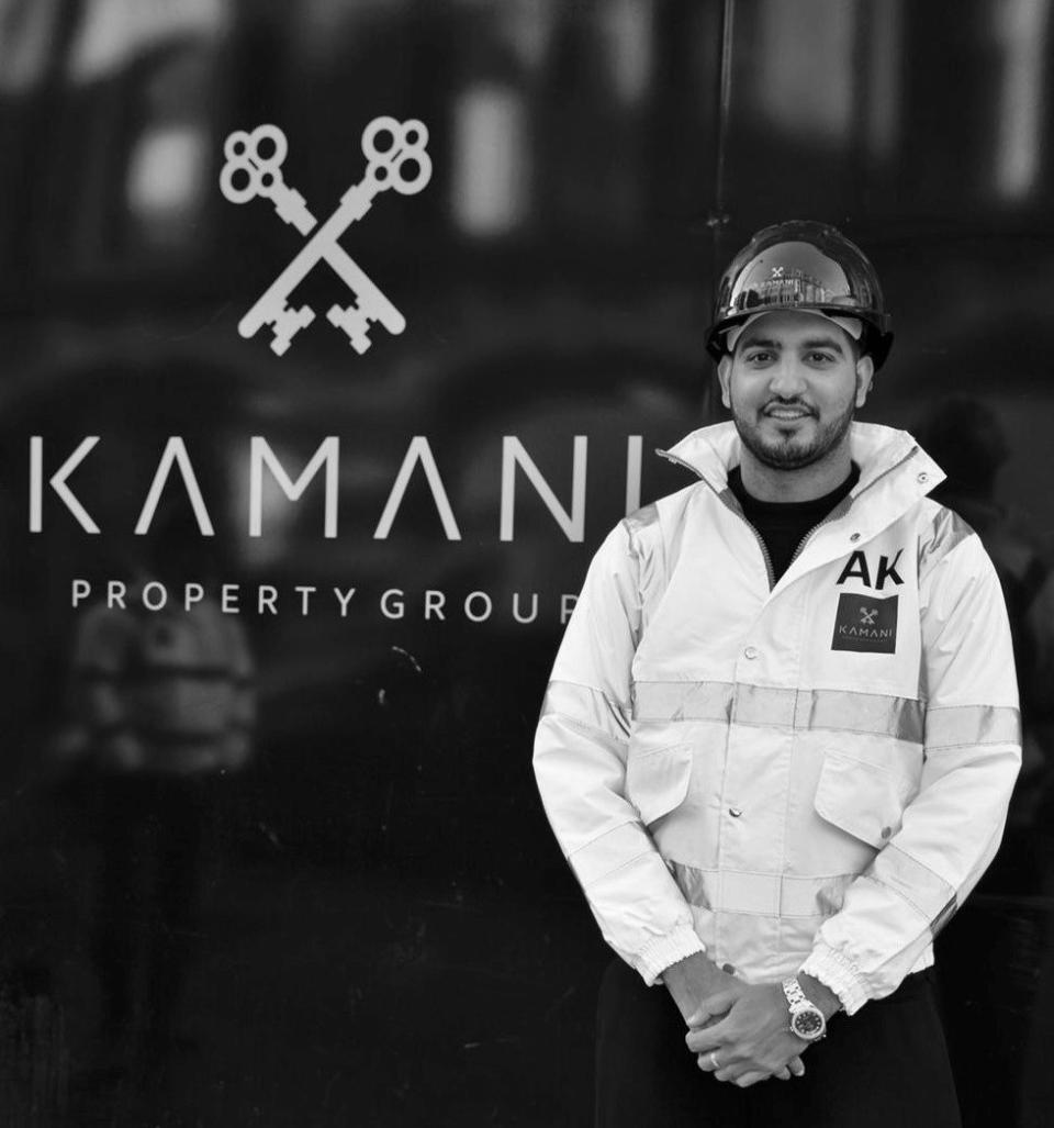 Adam Kamani, CEO of Kamani Property Group, stands confidently in front of the company logo in Manchester.