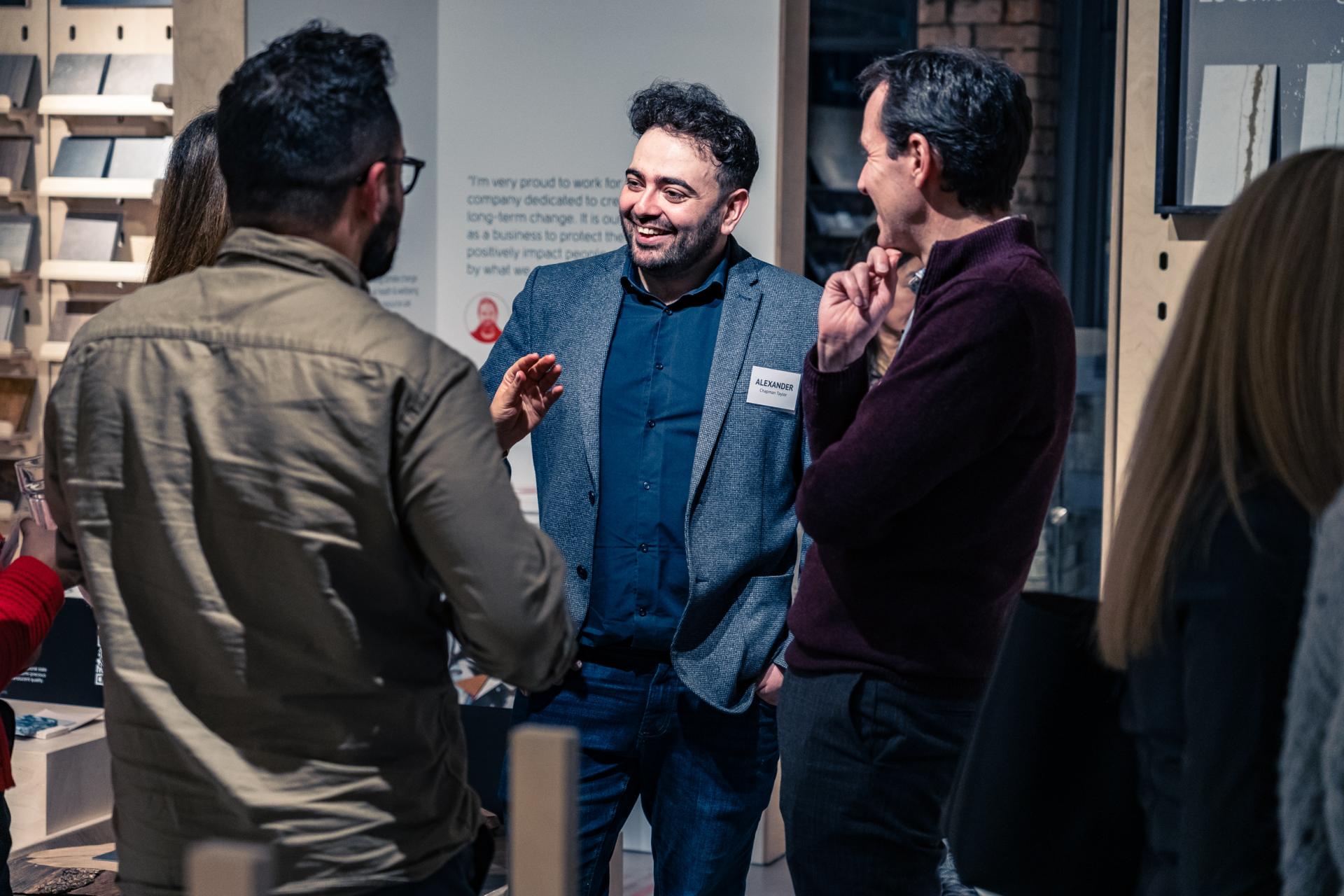 Professionals discussing sustainability and materiality strategies for achieving Net Zero during a networking event.