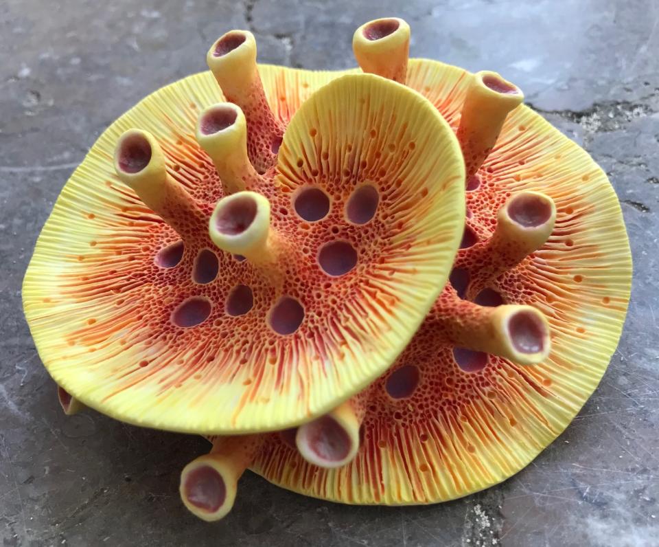 Vibrantly colored clay sculpture resembling oceanic coral, showcasing intricate textures and shapes inspired by marine life.