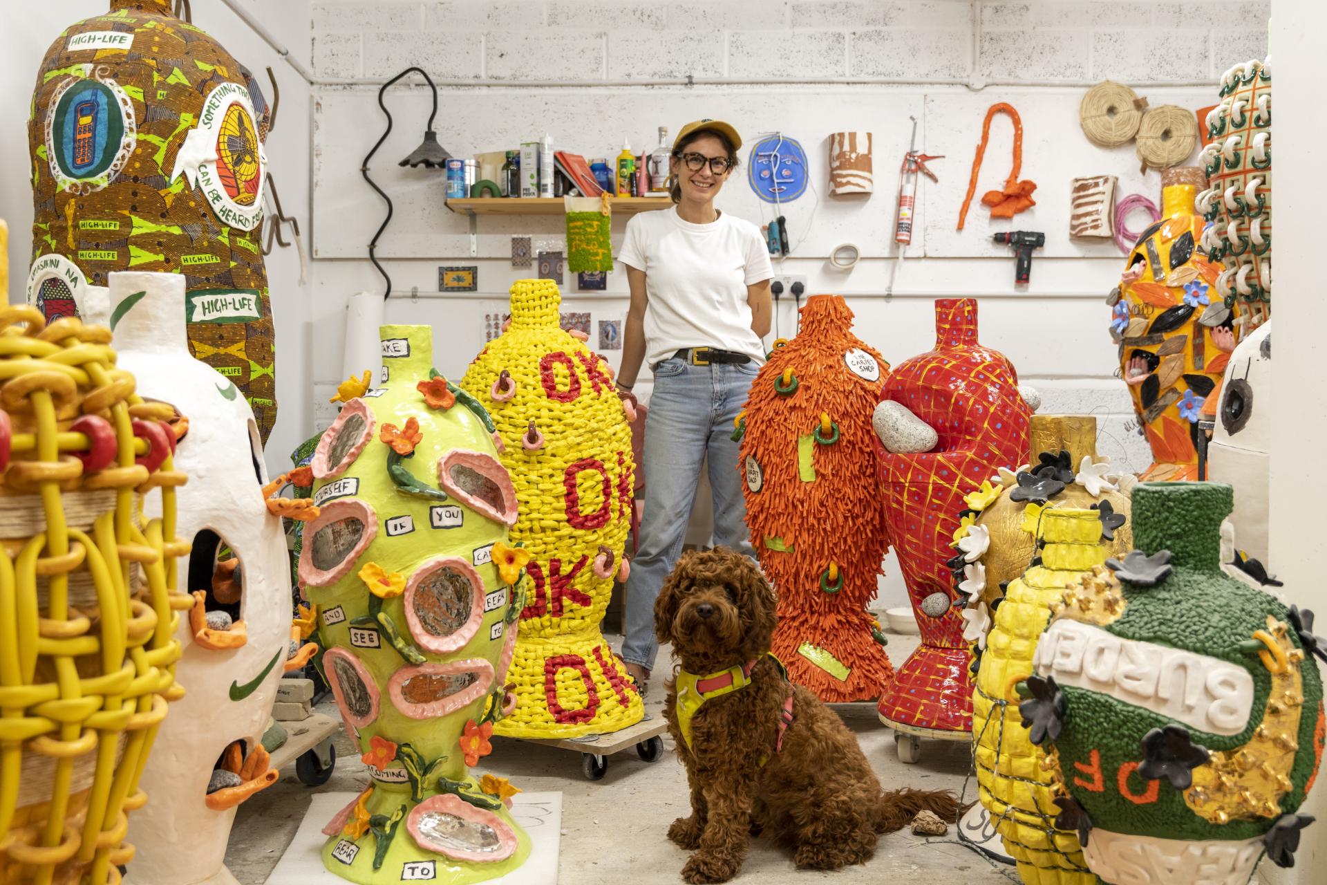 Artisan showcasing colorful ceramic sculptures in a vibrant studio, emphasizing craft and creativity for the Harewood Biennial 2024.