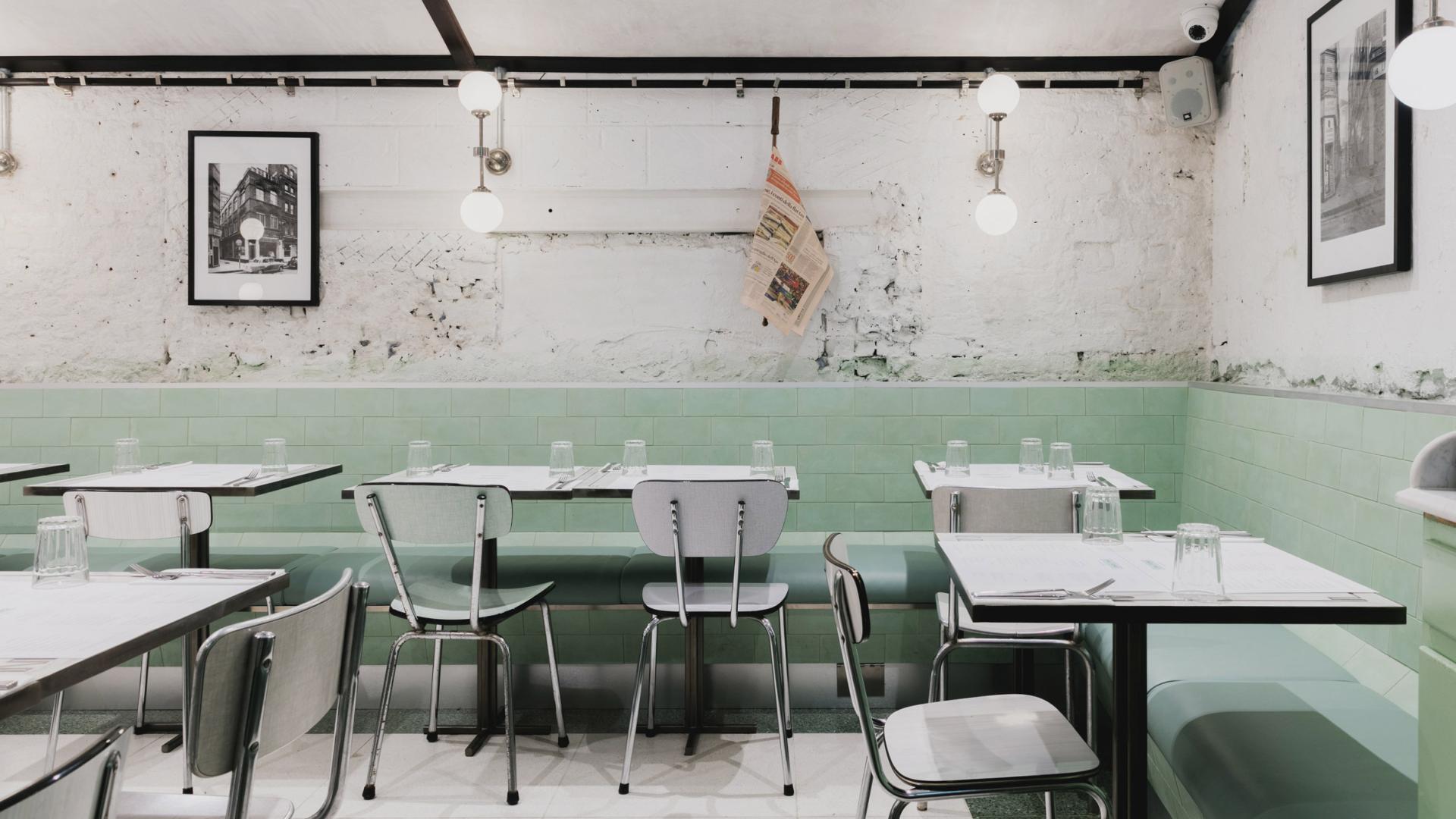 Art Deco-inspired interior of Lina Stores in Soho, featuring green and white striped tiles and minimalist furnishings.