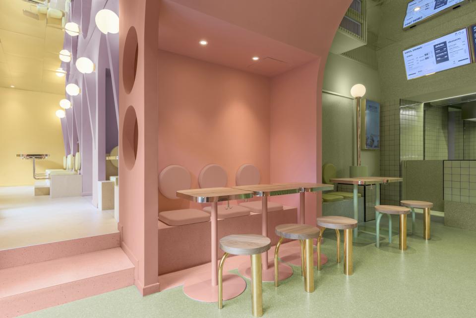 Brightly colored interior design of Masquespacio's Bun restaurant in Milan, featuring modern seating and playful decor elements.