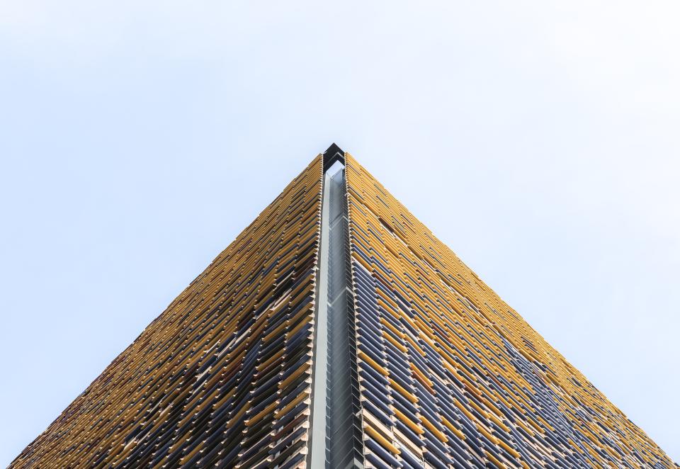 Architectural design featuring vibrant Spanish ceramics in a striking modern building, showcasing innovative use of tile in construction.