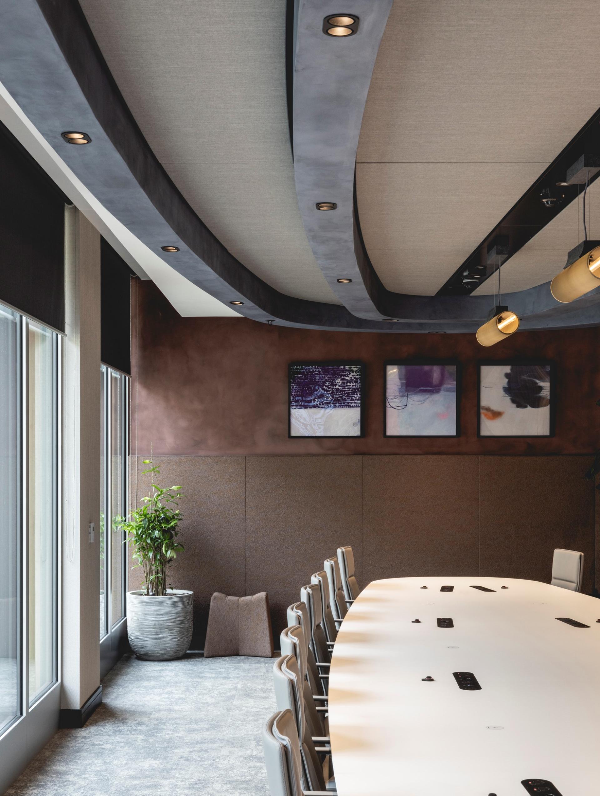 Elegant meeting room featuring Art Deco-inspired curves, a large oval table, and calming designs, showcasing Ekho Studio's workspace.