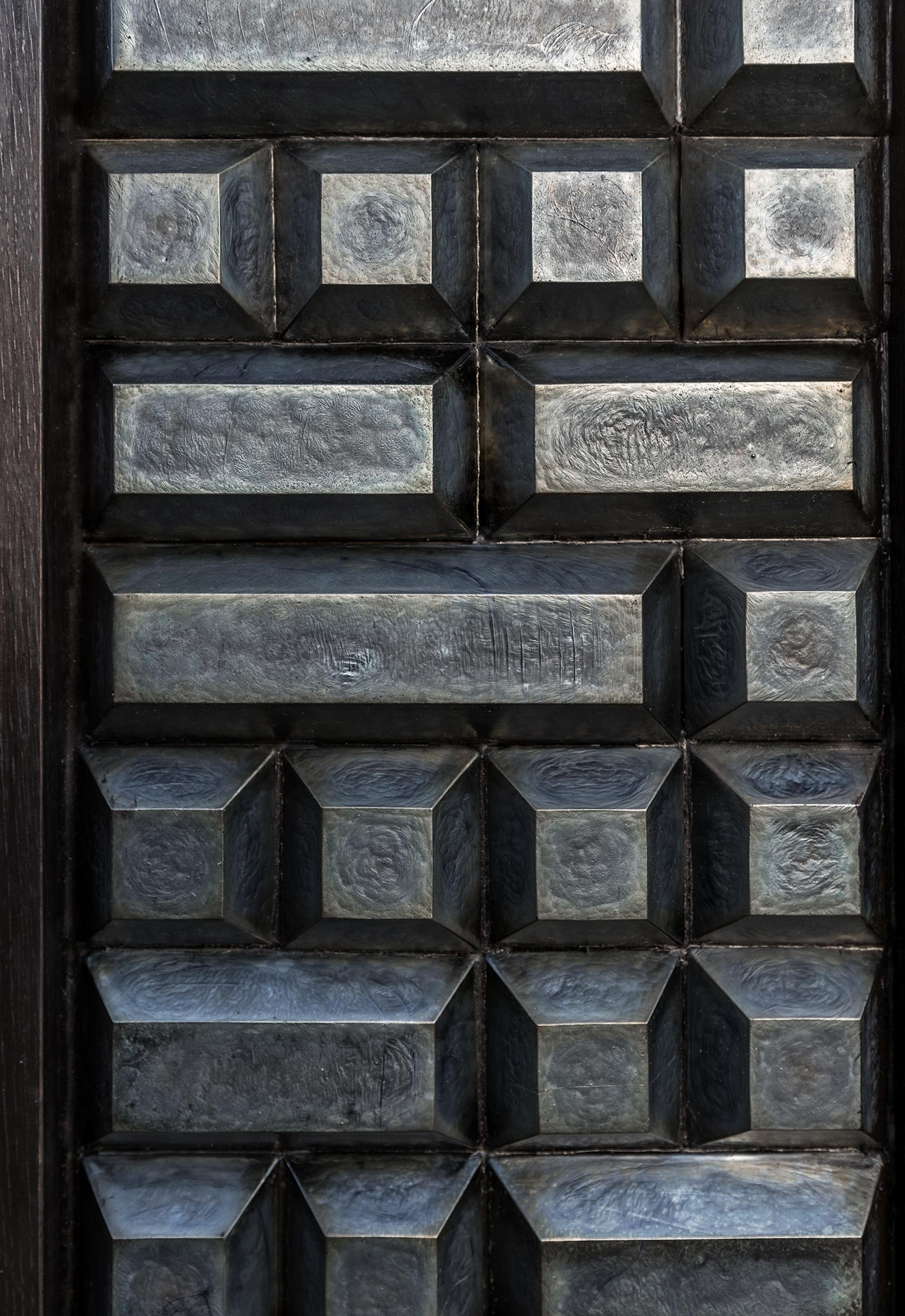 Textured metallic wall panel featuring geometric designs, reflecting innovative architectural style recognized in the Surface Design Awards 2019.